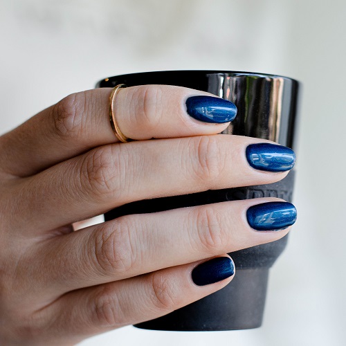 donker blauw gelakte nagels in de kleur 'Peackock Plume' van CCO met een koffiemok