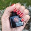 Hand met een rode cat's eye gellak in de kleur 'Bazahr'
