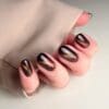Hand met bruin gelakte cat's eye nagels in de kleur 'Hummingbird' van CCO