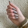 Hand met grijs gelakte gellak nagels "Brandon Beige " van Gelzz