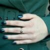 Hand met groen gelakte nagels in de kleur New Glitter petrol van Gelzz