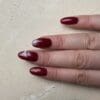 Hand met gelakte nagels in de kleuk Beaujolais G128 van Gelzz