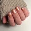 Hand met met gelakte gellak nagels in een nude kleur met glitters van het merk Gelzz