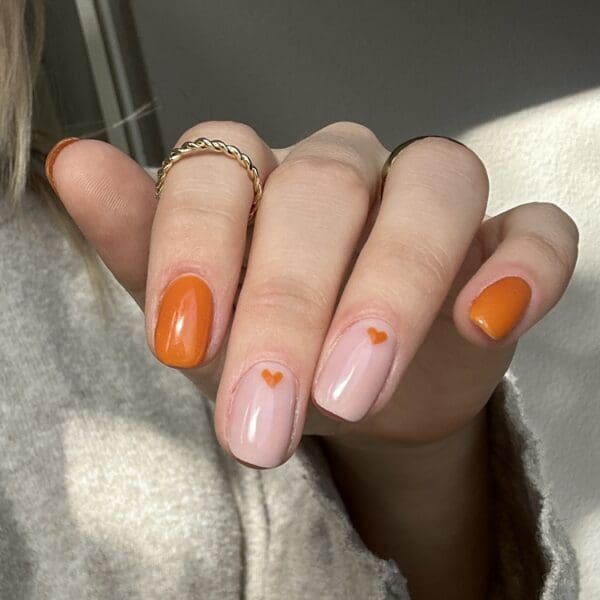 Nagels gelakt met een warme oranje gellak "Cardigan" van Gelzz