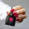 Hand met rood gelakte nagels welke een flesje Gelzz 'Business sophisticated' vasthoudt